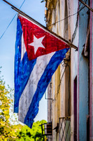 A Cuban Flag painted on canvas and displayed on the crumbling walls of Old Havana (La Habana), Cuba.