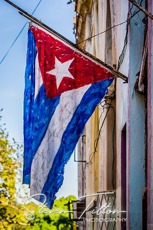 A Cuban Flag painted on canvas and displayed on the crumbling walls of Old Havana (La Habana), Cuba.