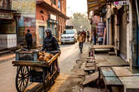 Local merchant pushes his cart down the street.